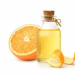 Eterično ulje narandže sa voćem i korom narandže izolovano na beloj pozadini.